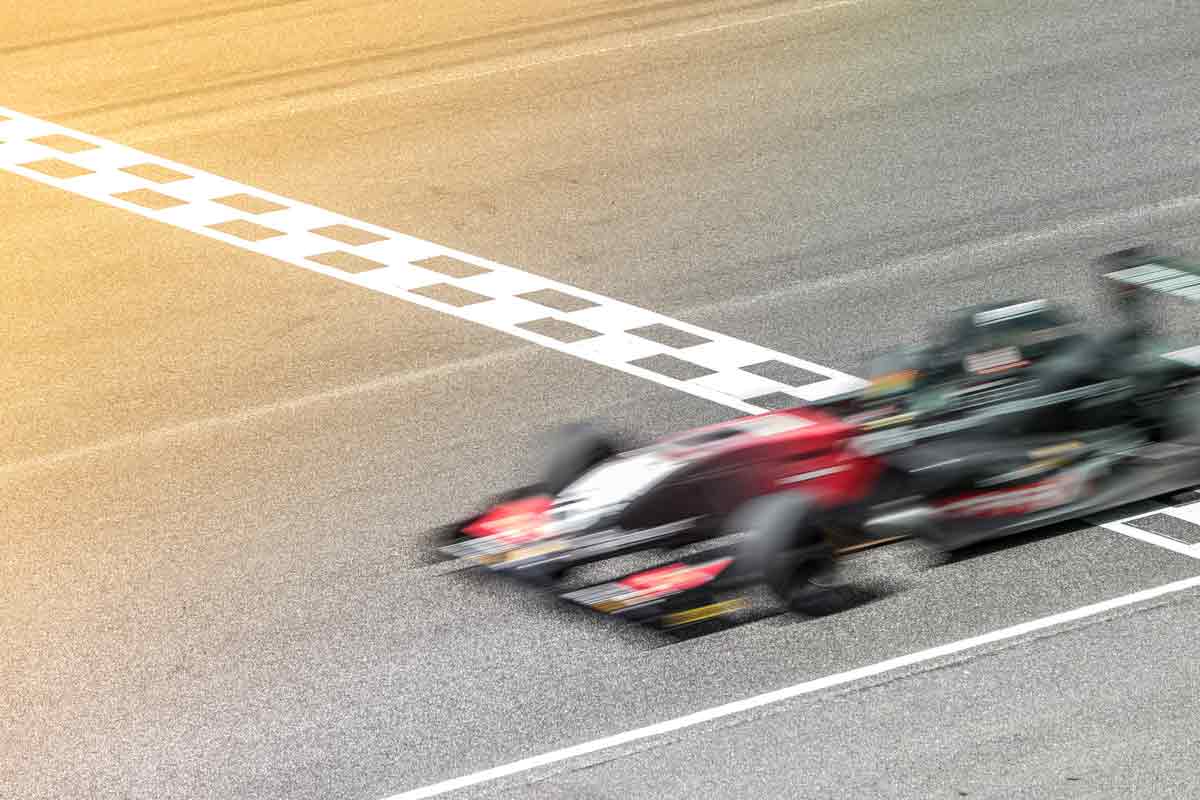 a blurred f1 car racing over the finish line